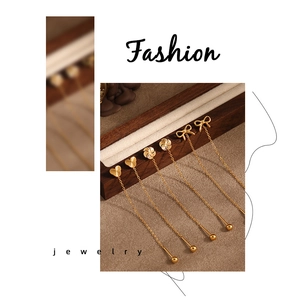 Detail of gold titanium steel ear threads with bow and windmill petal charms