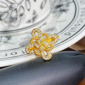 Makroaufnahme eines vergoldeten Knotenrings mit weißem Zirkonia auf Display