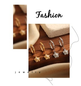 Detail of flower charm hoop earrings with pearls in gold and silver finishes