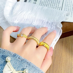 Détails de bagues dorées vintage avec zircon, perles et texture de métal brossé
