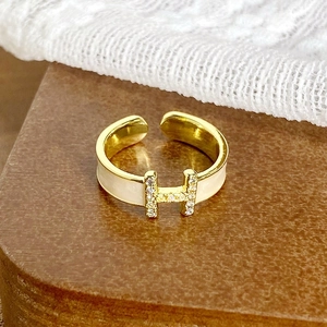Détail de la bague vintage en forme de H avec émail blanc et zircons brillants incrustés