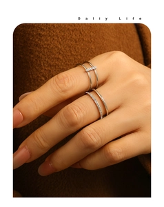 Détail de bagues double couche en argent avec zircons sur tissu en laine marron