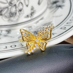 Detail eines goldenen Vintage-Schmetterlingsrings mit hohlen Flügeln und Zirkon-Inlay