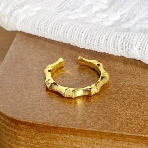 Vue détaillée de la bague dorée en forme de bambou ornée de cristaux de zircon blancs