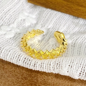 Vue macro d'une bague en émail doré avec textures ondulées et zircons brillants incrustés