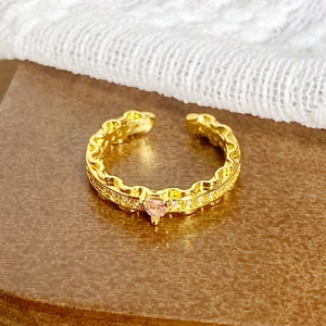 Vue détaillée d'une bague vintage en or avec pierre rose en cœur et détails en zircon