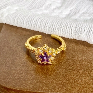 Détail d'une bague vintage avec zircon étoile violette et texture plaquée or luxe