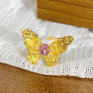 Vue détaillée d'une bague papillon dorée avec pierre violette et zircons