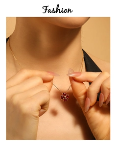 Dettaglio della collana a quadrifoglio rosso con quattro pietre a cuore su catena oro