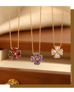 Dettaglio di collane a quadrifoglio con petali a cuore in cristallo rosso, viola e bianco