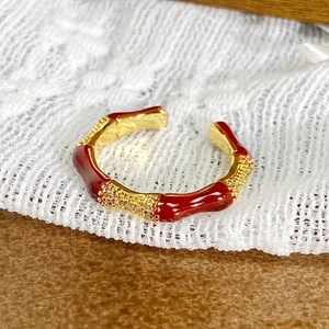 Détail de bague style bambou vintage avec finition or et incrustations émail rouge