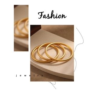 Close-up detail of three matte 24K gold plated minimalist bangles with a frosted texture