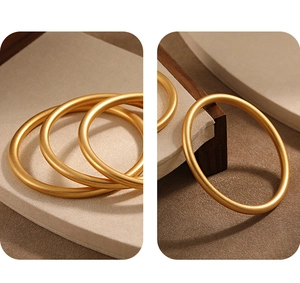 Detail view of matte 24K gold-plated bangle showing the 999 purity hallmark inside