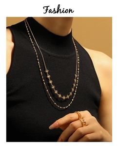Vue détaillée d'un collier trèfle à deux rangs et d'une bague dorée sur un mannequin