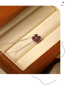 Dettaglio della collana a quadrifoglio con quattro pietre rosse a cuore in scatola di legno
