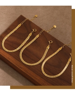 Detail of three-piece PVD gold snake bone chain bracelet with S925 engraved tag