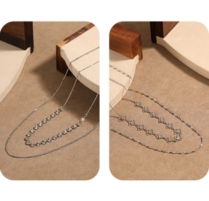 Vue détaillée de deux colliers argentés minimalistes avec pendentifs soleil et trèfle ajouré