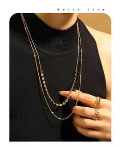 Détail d'un collier double épaisseur plaqué or avec disques solaires sur mannequin