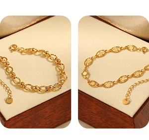 Detail view of 18K gold plated oval link bracelets with textured sunburst pattern and K18 tag