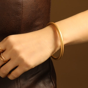 Elegant 24K gold plated matte bangle and sparkling stone ring set on female wrist