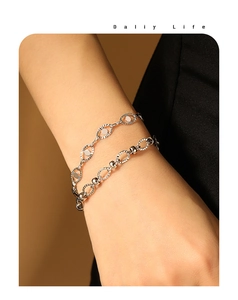 Detail of double-layer titanium steel bracelet with oval embossed links on wrist