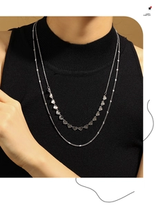 Détail d'un collier double rang en argent avec pendentifs cœur et texture radiale