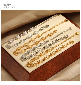 Detailed view of gold and silver oval-link bracelets with intricate floral carvings