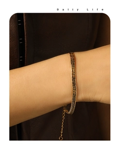 Close-up of golden herringbone chain bracelet showing detailed snake bone texture