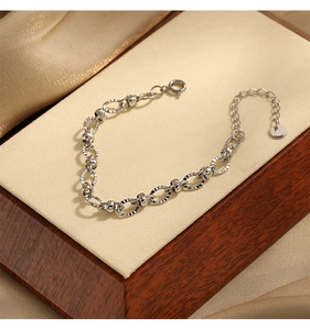 Macro detail of silver oval bead embossed chain bracelet with lobster clasp and extension