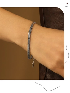 Detailed macro view of flat silver snake bone chain bracelet with layered metal textures