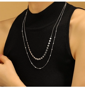 Gros plan d'un collier double épaisseur en argent avec médaillons soleil gravés
