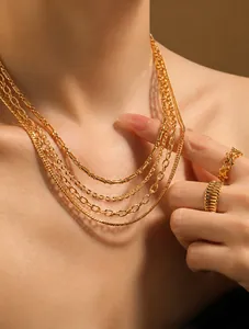 Detailansicht mehrlagiger vergoldeter Edelstahlketten und Ringe am Model getragen