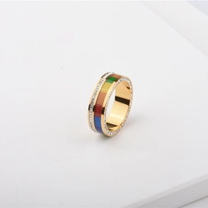 Detail of gold titanium ring with colorful enamel inlay and sparkling zircon border