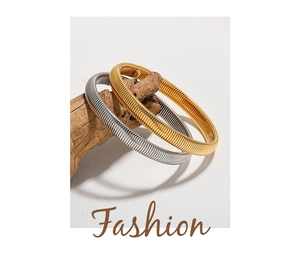 Detail of gold and silver snake bone elastic bracelets on a decorative wood branch
