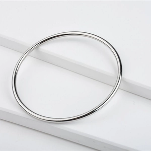 Minimalist geometric circular solid silver bracelet with a high-polished metallic finish