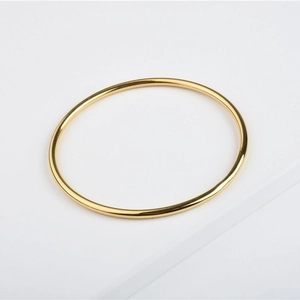 Close-up of a high-polished minimalist 24K gold plated stainless steel solid bangle