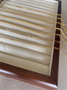 Collection de chaînes en acier inoxydable plaqué or 24K sur plateau à bijoux blanc