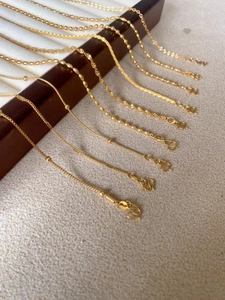 Détail de chaînes en titane plaqué or 24K avec fermoirs en S et gravure de pureté 999