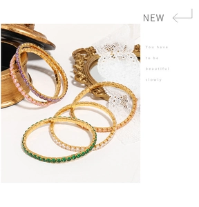 Detail view of five multicolor square zircon tennis bracelets with gold settings and gems