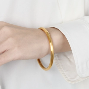 Classic 24k gold-plated matte stainless steel bangle on a female model wrist