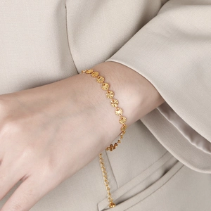 Elegant gold titanium steel bracelet with textured solar sequin discs on model wrist