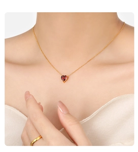 Gedetailleerde close-up van een hartvormige robijnen hanger aan een gouden ketting