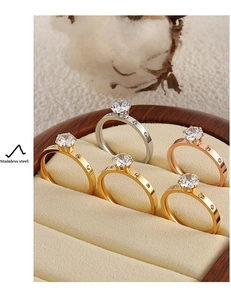 Detalle de cinco anillos de acero inoxidable con piedras en caja de terciopelo
