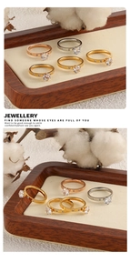 Detalle de tres elegantes anillos en oro, oro rosa y plata sobre una bandeja de exhibición