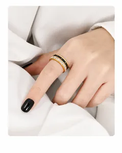 Detalle del anillo giratorio con números romanos en esmalte negro y circonitas doradas