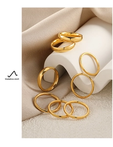 Set de anillos dorados de acero inoxidable sobre seda y soportes geométricos de lujo