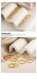 Set de anillos apilables de oro pulido sobre elegante tela crema con luz artística