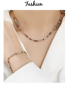 Dettaglio del set collana e bracciale con zirconi colorati e finitura oro