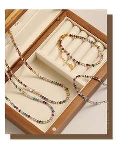 Dettaglio del set di gioielli con zirconi colorati esposti in una scatola regalo in legno