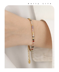 Dettaglio di un bracciale tennis dorato arcobaleno con zirconi marquise e catena estesa